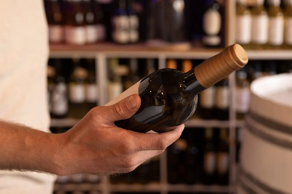 Customer holding a wine bottle in store while exploring Oktoberfest drinks deals 2025 at Wine Rack