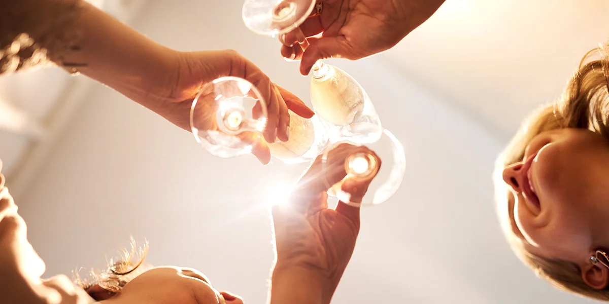 Friends raising glasses together in a bright celebratory moment, enjoying January drinks deals near you