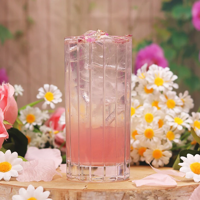 Mother’s Day and St Patrick’s Day drinks near you featured in a floral Blossom Rose cocktail served over ice with delicate pink tones and spring flowers in the background.